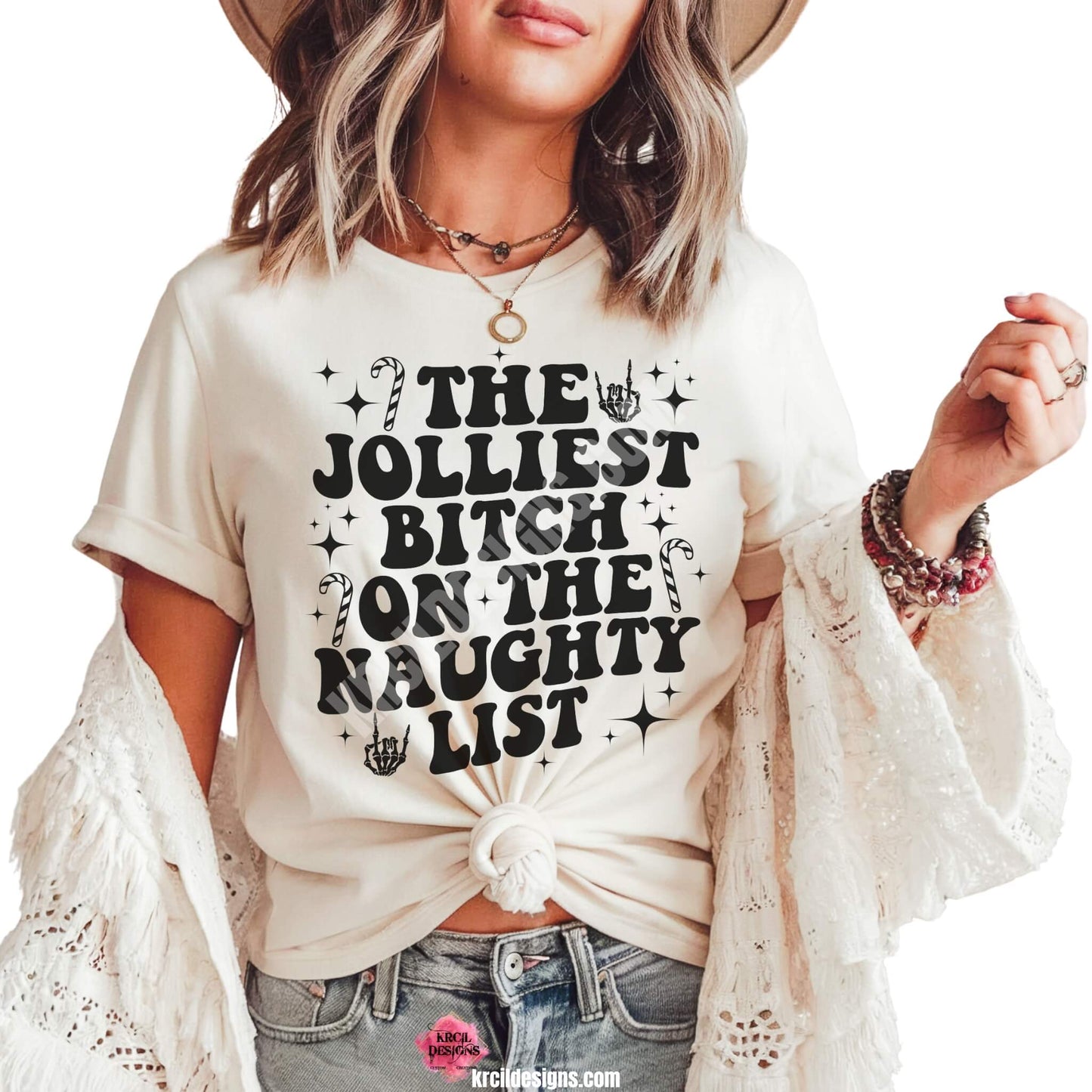 Christmas Tees by KrcilDesigns.com | Graphic design on a white t-shirt, featuring an all back design, bold black capital wavy retro letters, text that reads: "The Jolliest Bitch On The Naughty List" surround by diamond stars, candy canes, and a rock-on skeleton hand.