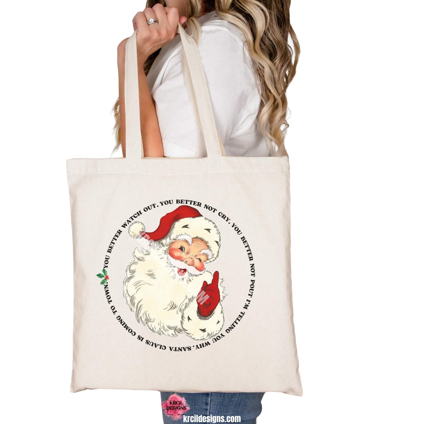 Christmas Tote Bags by KrcilDesigns.com | Graphic design on a canvas tote bag, features a vintage-style Santa Claus with rosy cheeks, winking and pointing, with the iconic song lyrics to: "Santa Claus Is Coming To Town" wrapped around Santa in a circle, in bold black capital vintage Christmas letters with green holly and red berries.