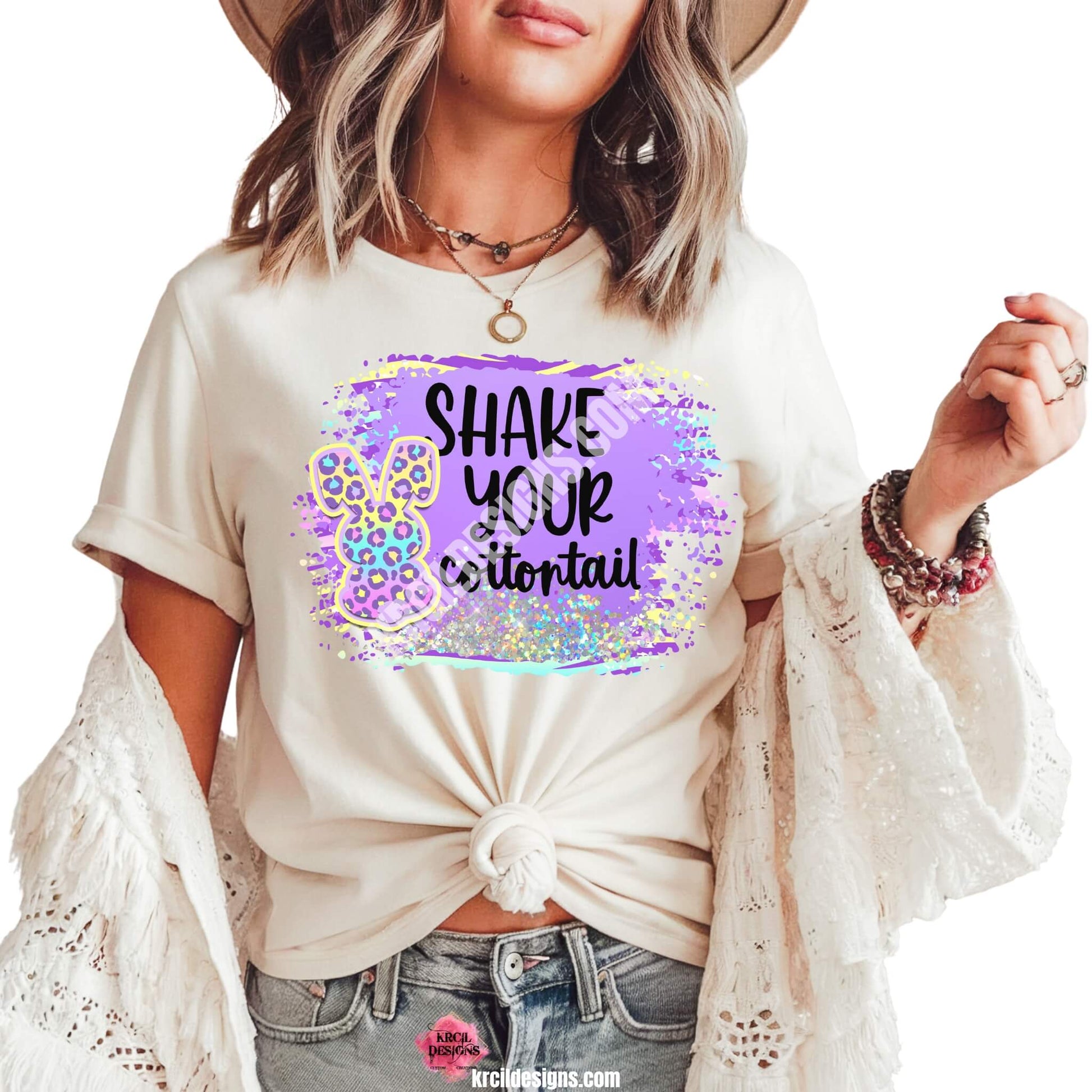 Shake Your Cottontail Easter T-Shirt by Krcil Designs | Make a fashion statement with our graphic tees t-shirts! Our buttery soft cozy tees will become your new weekend bestie! Get ready to hop into fun with our "SHAKE YOUR cottontail" Easter shirt! Our graphic design, showcasing a pastel cheetah print bunny and vibrant splashes of Easter colors. This Easter, celebrate in style with matching family shirts—perfect for family photos! Shop Easter Shirts at KrcilDesigns.com