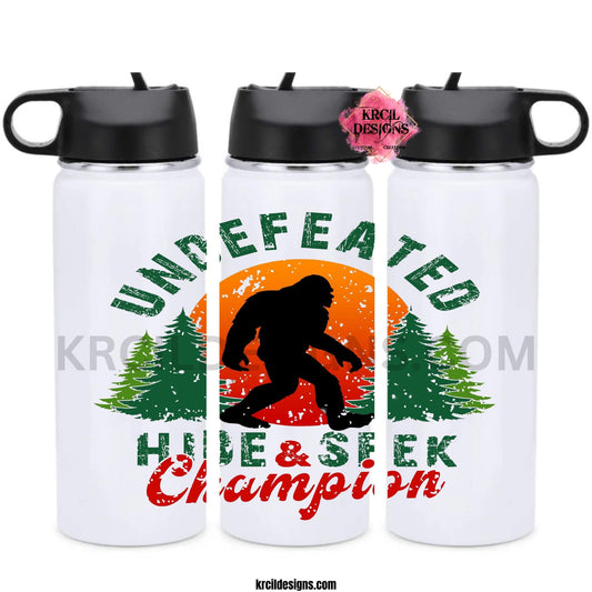 Bigfoot Water Bottles by KrcilDesigns.com | Graphic design on a white water bottle, featuring a graphic of a black silhouette of Bigfoot, walking in front of a red and orange sunset, with green pine trees on both sides, above Bigfoot, text that reads: "UNDEFEATED" in curved distressed bold block capital green letters, below, text that reads: "HIDE & SEEK" in distressed bold block capital green letters, with "Champion" overlay in bold red handwriting script.