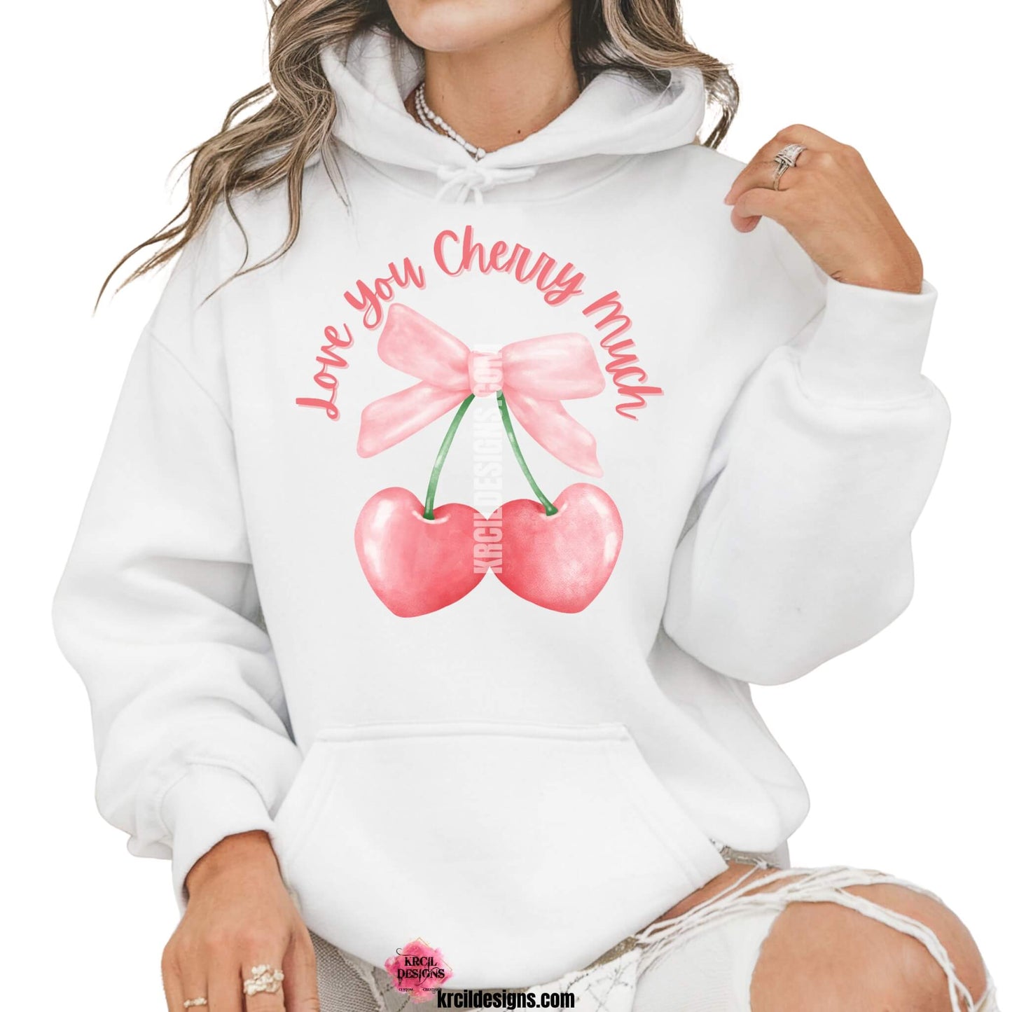 Coquette Bow Shirts by KrcilDesigns.com | Graphic design on a white hoodie, pink script font text that reads: "Love You Cherry Much" with a watercolor pink coquette bow and two pink cherry hearts dangling from bow.