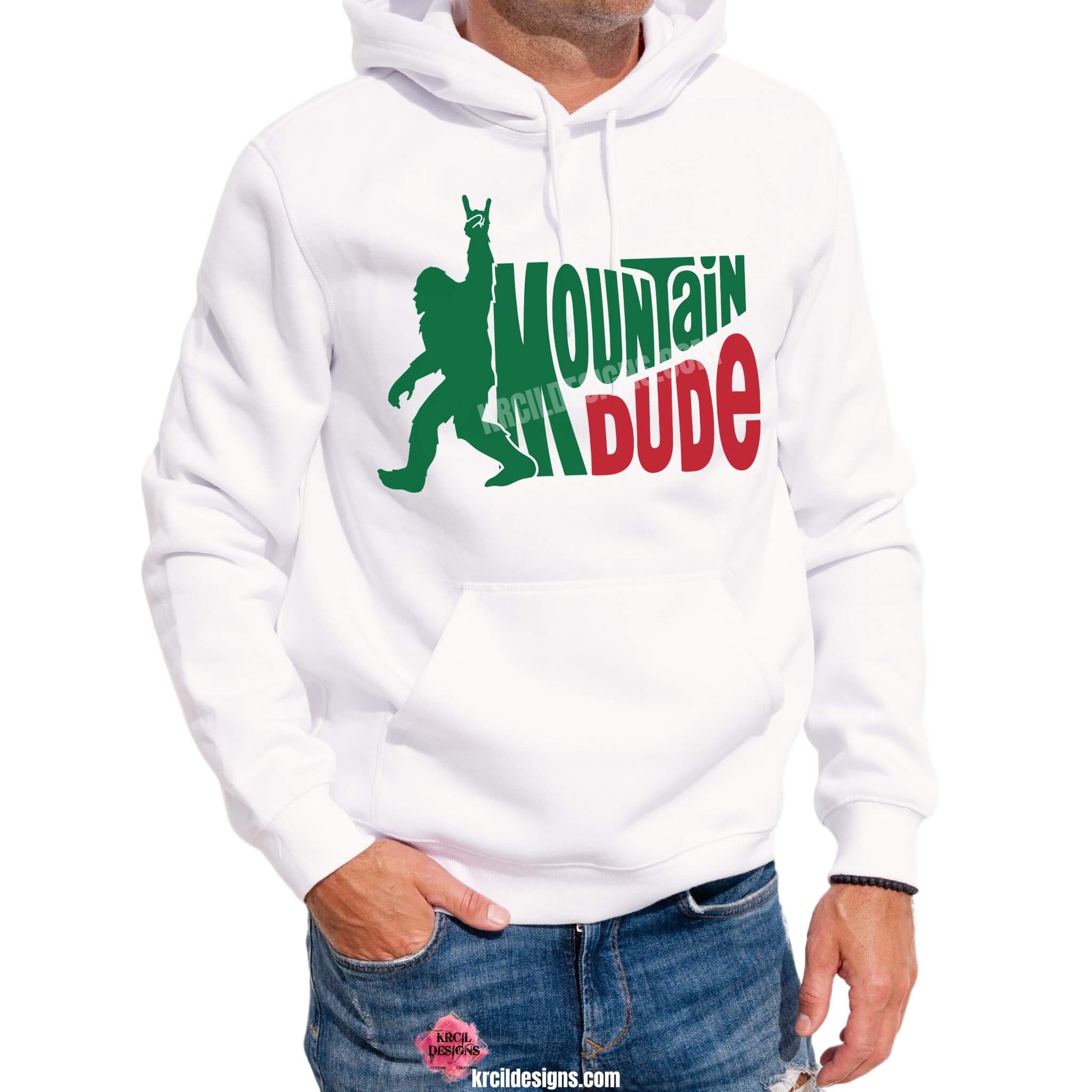 Bigfoot Shirts by KrcilDesigns.com | Graphic design on a white hoodie, featuring a green silhouette of Bigfoot walking with one arm raised and using a rock-on hand gesture, next to the figure, in waved bold capital letters text that reads: "MOUNTAIN DUDE," with "MOUNTAIN" in green and "DUDE" in red.
