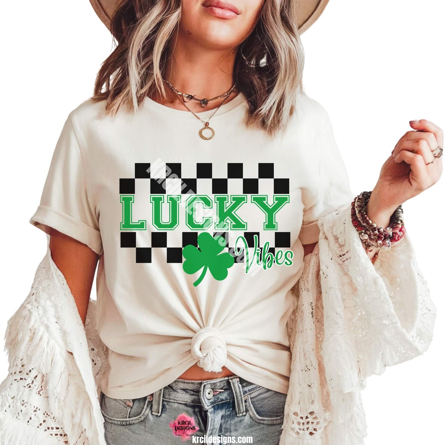 Lucky Vibes St. Patrick's Day T-Shirt by Krcil Designs | Make a fashion statement with our graphic tees t-shirts! Our buttery soft cozy tees will become your new weekend bestie! Get your green on this St. Patty's Day! Run your errands in style with our St. Patty's Day tote bag! Our graphics showcase a green shamrock the word lucky in green bold letters with a checkered border top and bottom. Shop Graphic Tees T-Shirts at KrcilDesigns.com