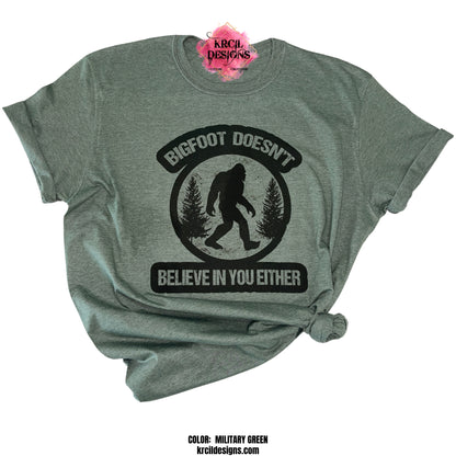 MILITARY GREEN | Show off your sense of humor with our Sasquatch T-Shirt "Bigfoot Doesn't Believe In You Either" Bigfoot T-Shirt by Krcil Designs! Featuring Bigfoot! The Bigfoot Tee that's a conversation starter at the Bigfoot Festival or on Bigfoot Day. Don't miss the fun — grab your Sasquatch Tee before it disappears into the woods! Give the gifts for Bigfoot lovers that make them roar with laughter! Keep the Bigfoot Legend Alive! Sasquatch: The Legend of Bigfoot! Shop Bigfoot Gifts at KrcilDesigns.com