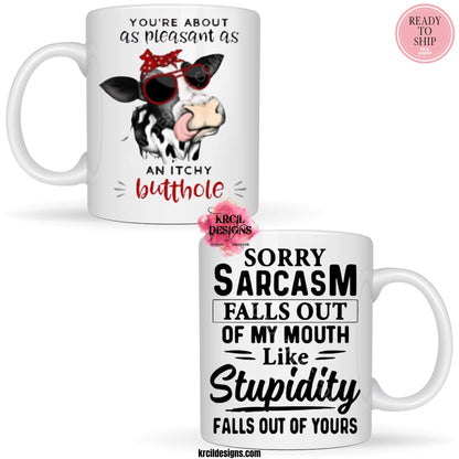 Funny Coffee Mugs by Krcil Designs | A white ceramic mug and sassy quotes on both sides of the mug. Graphic Design: a black and white spotted cow wearing a red and white polka dot bow and sunglasses. Front Side: text that reads: "You're About as Pleasant as an Itchy Butthole" Back Side: text that reads: "Sorry Sarcasm Falls Out Of My Mouth Like Stupidity Falls Out Of Yours" | Shop Coffee Mugs at KrcilDesigns.com