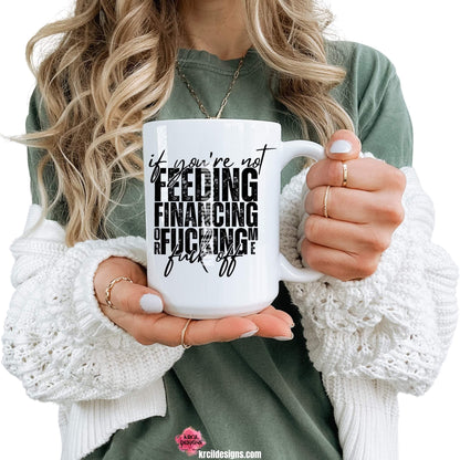 Sassy Funny Coffee Mugs by KrcilDesigns.com | Graphic design on a white ceramic mug, featuring bold black text that reads: "if you're not FEEDING FINANCING or FUCKING me fuck off" with a distressed, stacked block-letter design and a handwritten script overlay for emphasis.