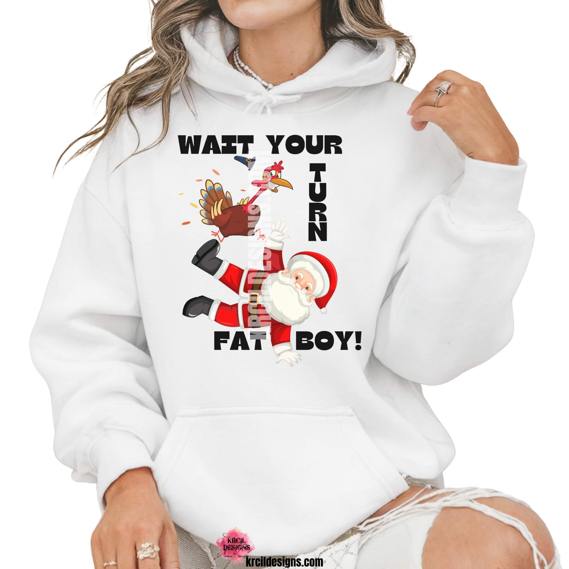 Funny Thanksgiving Shirts by KrcilDesigns.com | Graphic design on a white hoodie, featuring a cartoon Thanksgiving turkey wearing a pilgrim hat, stomping on Santa Claus, with playful motions and feathers flying. Bold black text in all caps, surrounds the scene, that reads: "WAIT YOUR TURN FAT BOY!" Fun holiday shirts that blend Thanksgiving and Christmas humor.