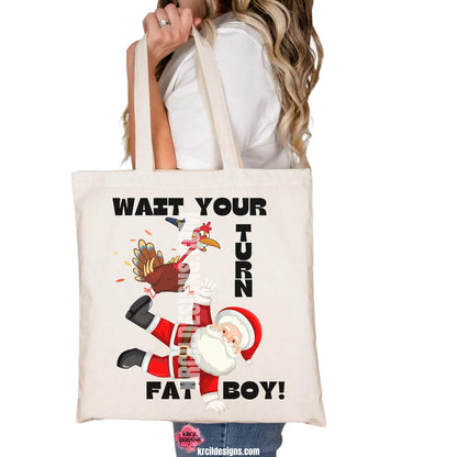 Thanksgiving Funny Tote Bags by KrcilDesigns.com | Graphic design on a canvas tote bag, featuring a cartoon Thanksgiving turkey wearing a pilgrim hat, stomping on Santa Claus, with playful motions and feathers flying. Bold black text in all caps, surrounds the scene, that reads: "WAIT YOUR TURN FAT BOY!" Fun holiday shirts that blend Thanksgiving and Christmas humor.