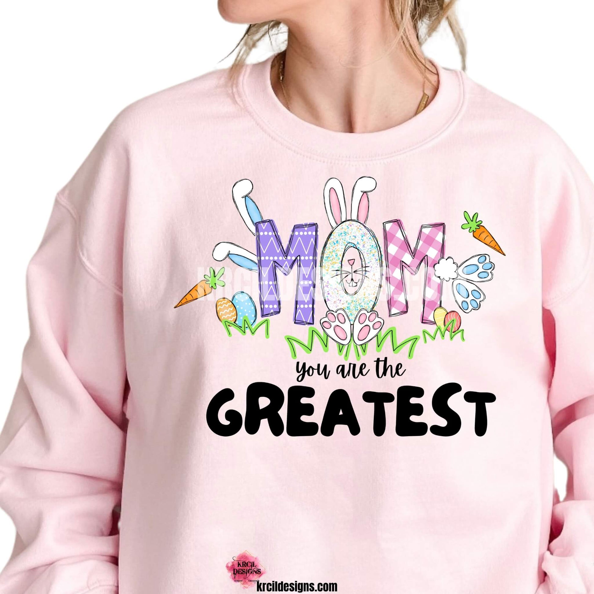 Easter Personalized Name Shirts, Sweatshirts and Hoodies by KrcilDesigns.com | Pink crewneck sweatshirt, features your name, the letters are in different easter pastel patterns, one letter has a pink or blue Easter bunny character with bunny ears, bunny feet, and bunny tail, other letters have bunnies hopping into them. Surrounding the letters are colorful Easter eggs, carrots, and the letters atop a row of grass. Add the kids names and make it truly yours!