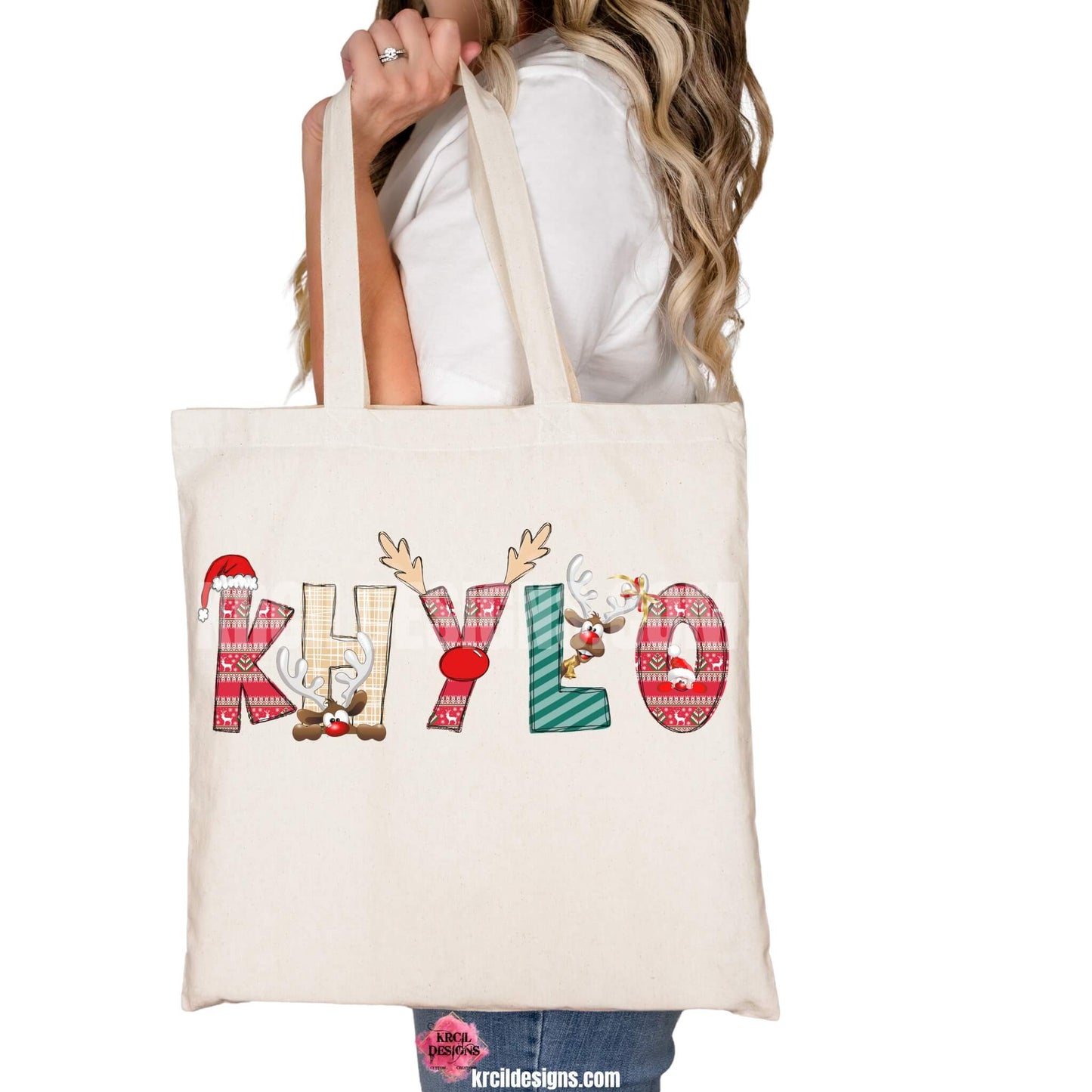 Christmas Personalized Tote Bags by KrcilDesigns.com | Graphic Design on a canvas tote bag, features your name, in name style option: "Christmas" where the designs of the letters are different festive Christmas patterns. The letters don a Santa Hat, Rudolph's Red Nose, and Reindeer Antlers. Santa and his Reindeer are playing Peek-a-Boo and are peeking out of letters.