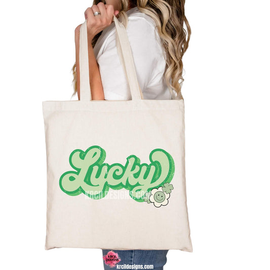 Lucky Shamrock St. Patrick's Day Retro Tote Bags by Krcil Designs | Make a fashion statement with our tote bags! Meet our shopper bags—your new sidekick! You know, the ones that always tag along and never lets you down—it's about to become your favorite fashion accessory! Perfect for grocery shopping or errands. Our graphics showcases the word LUCKY in bold retro style green letters, outlined in two shades of green, adorned with shamrocks and a smiley flower. Shop Tote Bags at KrcilDesigns.com