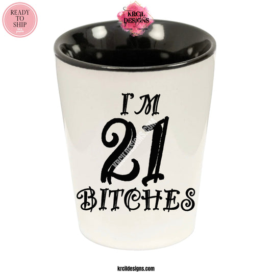 "I'm 21 Bitches" Shot Glass by Krcil Designs | Get ready to toast to the good times with our custom personalized shot glasses, perfect for the man cave. Pair them with your favorite bottle of liquor and put them in a basket for the ultimate gift. Don't forget to add the matching dish cloth tea towel set! Explore our sets and bundles options for gift ideas. Perfect for birthdays and holidays. Two toned, black interior, white exterior, ceramic shot glass. KrcilDesigns.com