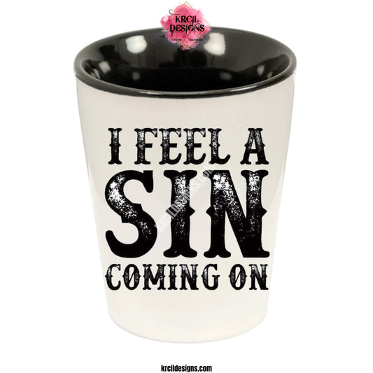 "I Feel a Sin Coming On" Shot Glass by Krcil Designs | Get ready to toast to the good times with our custom personalized shot glasses, perfect for the man cave. Pair them with your favorite bottle of liquor and put them in a basket for the ultimate gift. Don't forget to add the matching dish cloth tea towel set! Explore our sets and bundles options for gift ideas. Perfect for birthdays and holidays. Two toned, black interior, white exterior, ceramic shot glass. KrcilDesigns.com