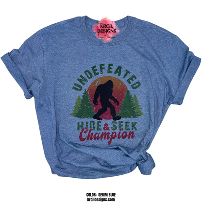 Sasquatch aka Bigfoot Tees "Undefeated Hide & Seek Champion" Custom T-Shirt by Krcil Designs | Design Your Own T-Shirt with Krcil Designs! | Custom T-Shirts, picture tees, photo t-shirts, sarcastic funny tees, special occasions, holidays and birthday t-shirts, bride-to-be bride tribe tees. Brand your business with our business logo t-shirts. Our unisex t-shirts are soft and cozy. For the ultimate gift, roll them up, stuff in a cup, or custom tote bag! KrcilDesigns.com