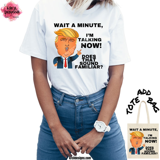 Wait A Minute, I'm Talking Now Trump T-Shirt by Krcil Designs | Make a fashion statement with our graphic tees t-shirts! Our buttery soft cozy tees will become your new weekend bestie! Our design showcases Donald J. Trump as a vibrant cartoon character, complete with his iconic signature swooping blonde hair and an exaggerated, animated facial expression. In classic Trump fashion, he's pointing his finger emphatically, ready to take command of the conversation! Shop Graphic Tees T-Shirts at KrcilDesigns.com