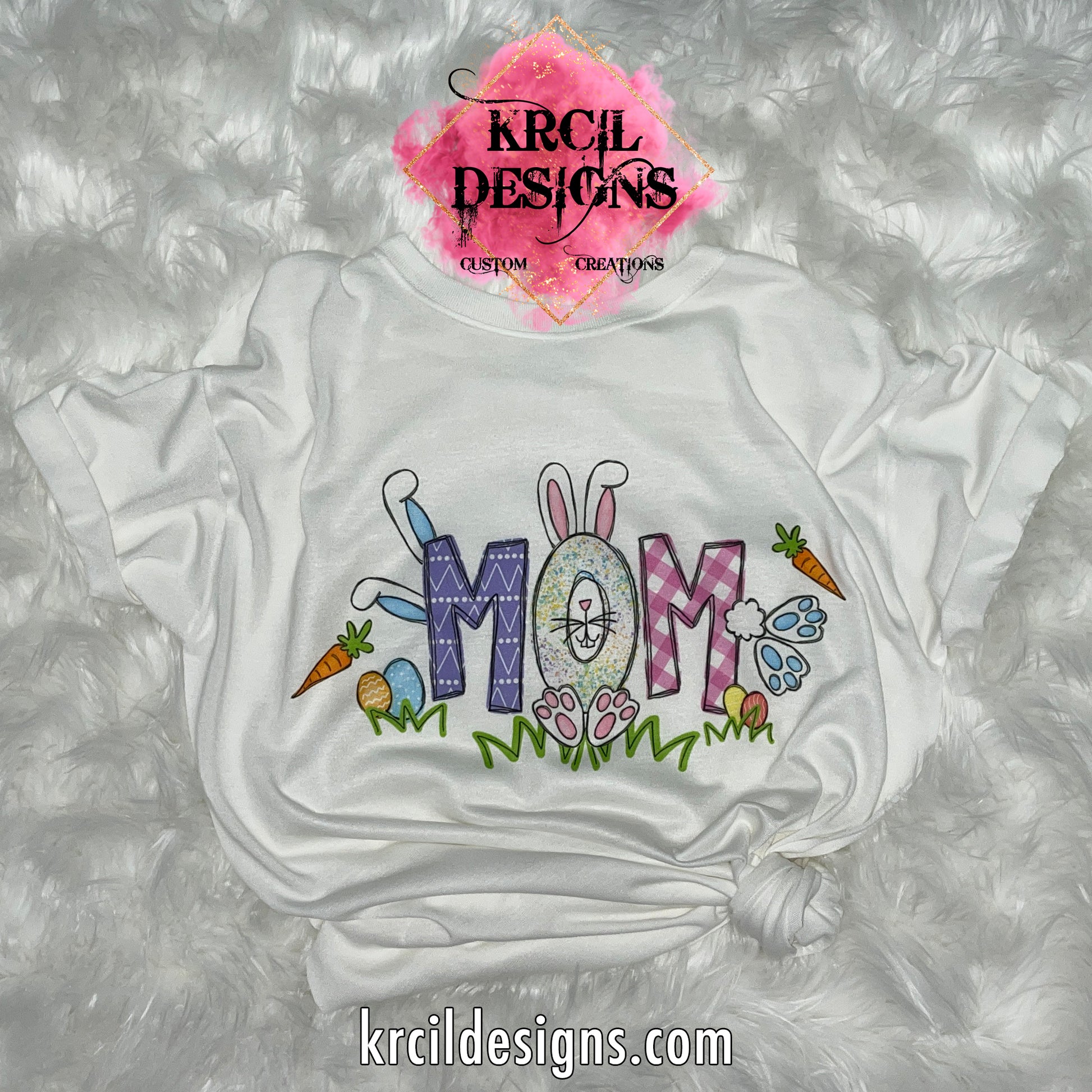 MOM | White | Your Name Easter T-Shirt by Krcil Designs | Our custom t-shirt, features your name, one lucky letter will be transformed into an adorable Easter bunny, while playful bunnies hop into the other letters. Surrounding the letters are colorful Easter eggs, carrots, and the letters atop a row of grass. Personalized T-Shirt—add the kids names and make it truly yours! This Easter, celebrate in style with matching family t-shirts—perfect for family photos! Shop Easter Shirts at KrcilDesigns.com