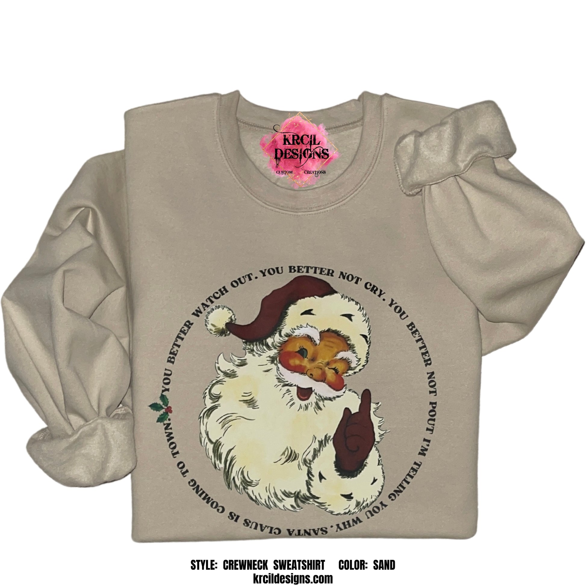 Sand Crewneck | Vintage Santa Claus Is Coming To Town Christmas Sweatshirt by Krcil Designs | Make a fashion statement with our hoodies and sweatshirts! Snuggle up in this cute Christmas Sweater and get in the festive spirit with our vintage Santa Claus and the iconic lyrics that are beautifully wrapped around a jolly Santa and adorned with holly and berries. This holiday season, celebrate in style with our Christmas shirts for family — perfect for family photos! Shop Christmas Sweaters at KrcilDesigns.com