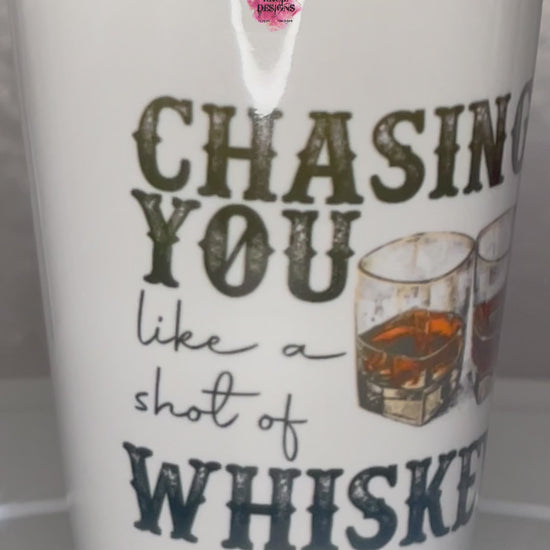 "Chasing You Like a Shot of Whiskey" Shot Glass by Krcil Designs | Get ready to toast to the good times with our custom personalized shot glasses, perfect for the man cave. Pair them with your favorite bottle of liquor and put them in a basket for the ultimate gift. Don't forget to add the matching dish cloth tea towel set! Explore our sets and bundles options for gift ideas. Perfect for birthdays and holidays. Two toned, black interior, white exterior, ceramic shot glass. KrcilDesigns.com