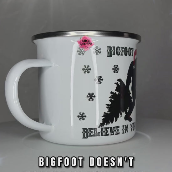 Sasquatch aka Bigfoot Christmas Mug | Personalized Mug by Krcil Designs | "Bigfoot Doesn't Believe in You Either" | This jolly Bigfoot is fully immersed in the holiday spirit, from dragging a Christmas tree to wearing a Santa hat and carrying a Bigfoot-sized candy cane. Adorned with whimsical black snowflakes, this festive mug can be personalized with your name with our black and white plaid letters for that extra touch of holiday magic. KrcilDesigns.com