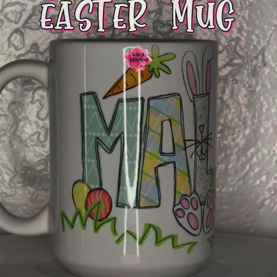 Easter Personalized Coffee Mugs by Krcil Designs | A white ceramic mug featuring your name. One lucky letter will be transformed into an adorable Easter bunny, while playful bunnies hop into the other letters. Their cute little tails and feet are sure to make you smile. Surrounding the letters are colorful Easter eggs and carrots. | Shop Easter Mugs at KrcilDesigns.com