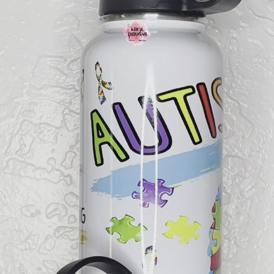 Autism Awareness Water Bottle by Krcil Designs | A gnome inspired water bottle that's perfect for spreading joy and promoting autism awareness. Featuring a colorful cheerful gnome wearing a puzzle-piece hat, surrounded by a cascade of puzzle pieces, and the autism puzzle-piece ribbon. | Let our custom water bottles do the talking with our collection of personalized water bottles. Personalize It - add name. Insulated stainless steel water bottles include 2 lids-wide mouth/flip top straw. KrcilDesigns.com