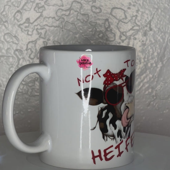 Funny Coffee Mugs by Krcil Designs | A white ceramic mug and sassy quotes on both sides of the mug. Graphic Design: a black and white spotted cow wearing a red and white polka dot bow and sunglasses. Front Side: text that reads: "Not Today Heifer" Back Side: text that reads: "Buckle Up Buttercup You Just Flipped My Heifer Switch" | Shop Coffee Mugs at KrcilDesigns.com