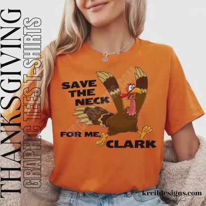 Funny Thanksgiving Shirts by KrcilDesigns.com | Graphic design on a orange t-shirt, featuring a cartoon turkey running with a panicked expression, wings flapping, and text that reads: "Save The Neck For Me, Clark" in bold black letters.
