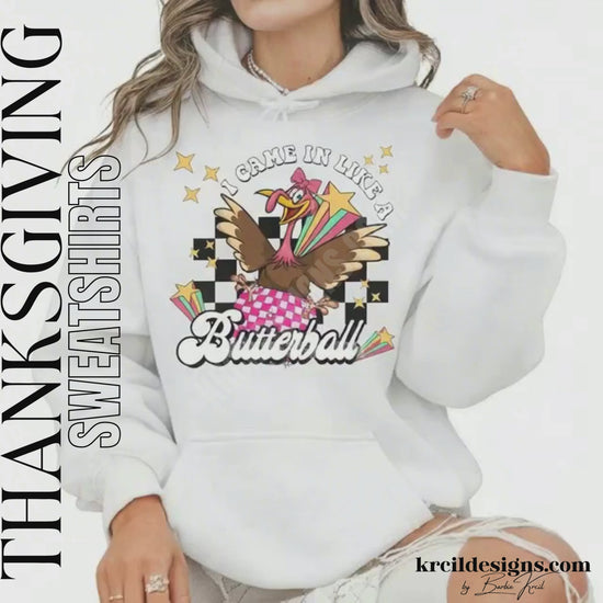 Funny Thanksgiving Shirts by KrcilDesigns.com | Graphic design on a white hoodie, featuring a fun Thanksgiving-themed design of a cartoon turkey swinging in on a disco ball in light pink and dark pink pattern, wearing a pink bow, surrounded by yellow stars, colorful retro stripes, and a black checkered background. Bold text above that reads: "I Came In Like A" with "Butterball" in large retro font below.