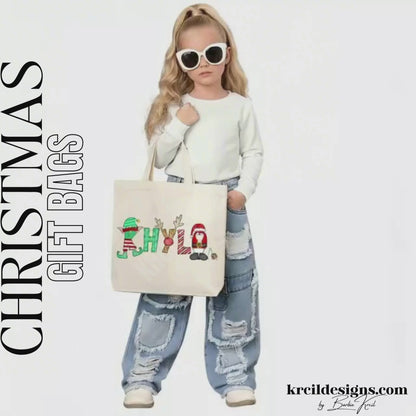 Christmas Personalized Tote Bags by KrcilDesigns.com | Graphic Design on a canvas tote bag, features your name,  in name style option: "Santa & Elf" where the designs of the letters are different festive Christmas patterns. The playful letters adorned with Santa, His Elf, Rudolph's Red Nose, Reindeer Antlers, and even Santa's Milk and Cookies.