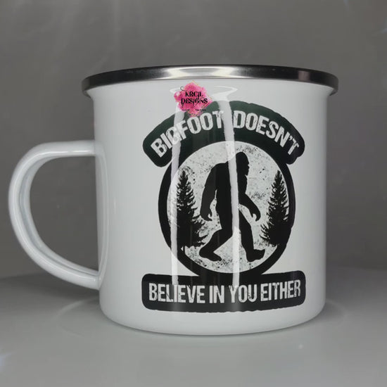 Sasquatch aka Bigfoot Camp Mug "Bigfoot Doesn't Believe in You Either" Metal Enamel Mug by Krcil Designs | Let our custom coffee cups do the talking with our collection of personalized coffee cups. Personalize It - add name, monogram, make a one-of-a-kind picture collage photo cup - the picture-perfect present! Add our dish cloth and tea towel set, perfectly paired with our cups and mugs. For the ultimate coffee lovers gift, explore our sets and bundles. KrcilDesigns.com