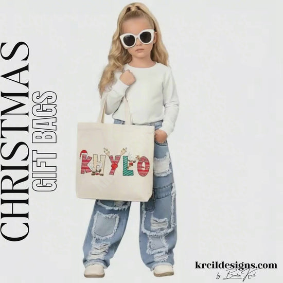 Christmas Personalized Tote Bags by KrcilDesigns.com | Graphic Design on a canvas tote bag, features your name, in name style option: "Christmas" where the designs of the letters are different festive Christmas patterns. The letters don a Santa Hat, Rudolph's Red Nose, and Reindeer Antlers. Santa and his Reindeer are playing Peek-a-Boo and are peeking out of letters.